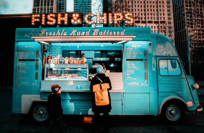 A modern 'Fish & Chips' food truck business at night.