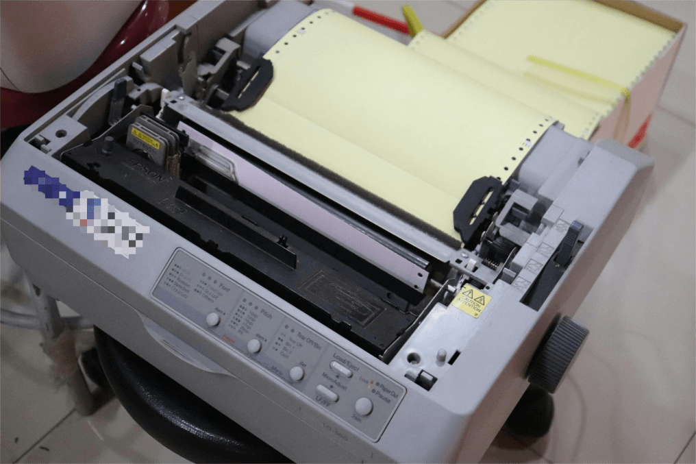 A classic dot matrix printer with continuous feed paper.